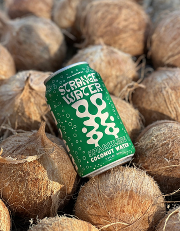 Can of Strange Water Sparkling Coconut Water among coconuts 