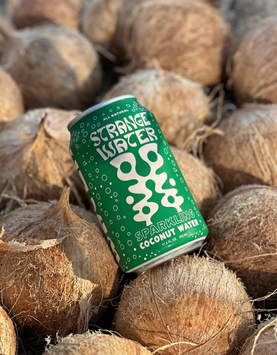 Can of Strange Water Sparkling Coconut Water among coconuts 